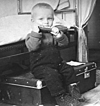 Дмитрий Татаркин в раннем возрасте с губной гармошкой